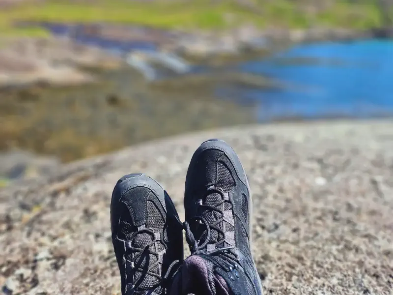 Hiking boots on the rocks right by the water