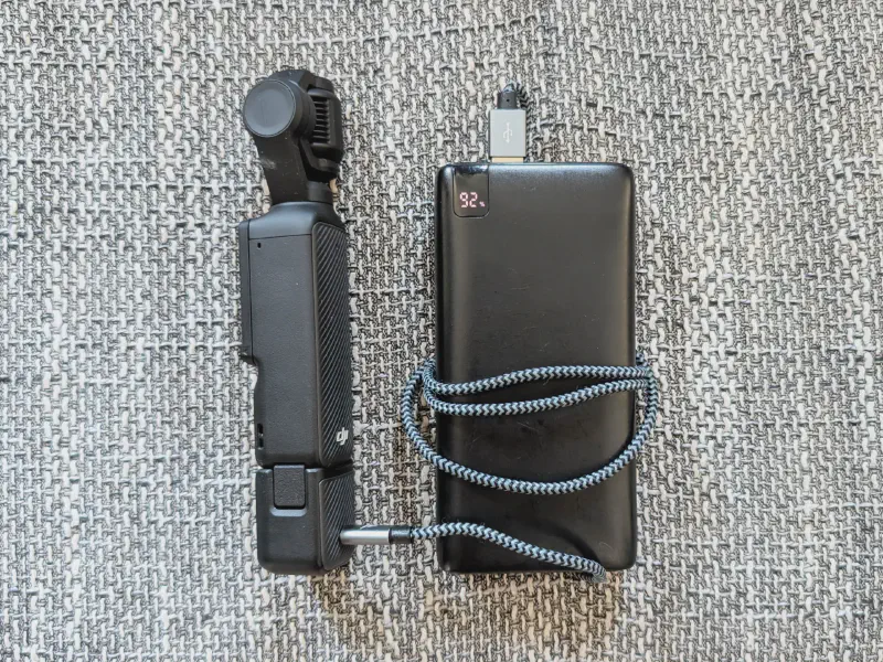 Power bank charging a DJI Osmo Pocket camera.