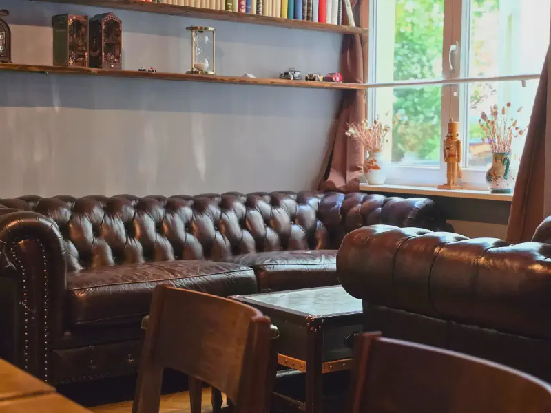 Chesterfield-Sofas unter einem Vintage-Regal mit Büchern
