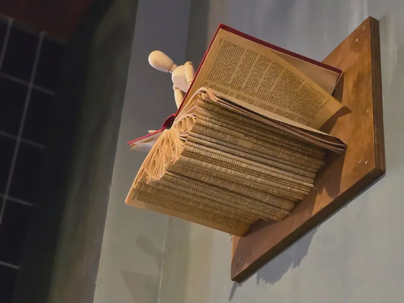 Gefaltetes Buch als Wandkunst mit hölzerner Gliederpuppe
