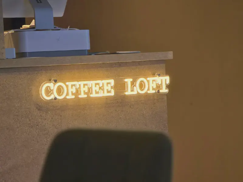 Glowing Coffee Loft neon sign at the counter