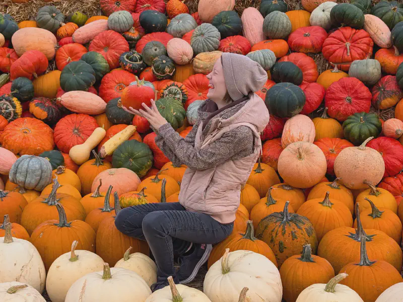 Gina laughing with a pumpkin in her hand