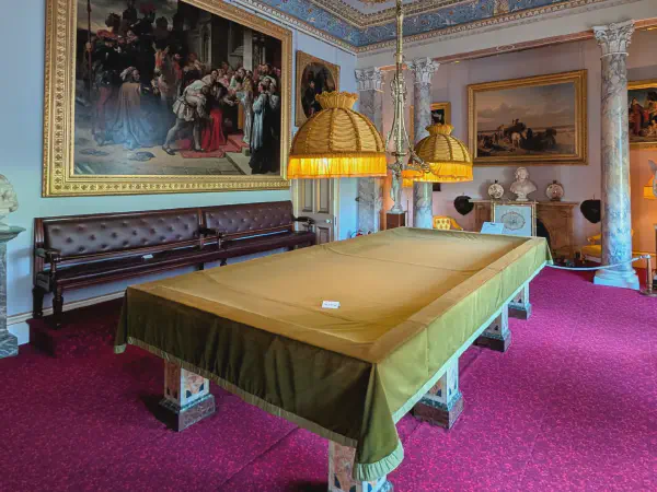 A large billiards table in front of a painting