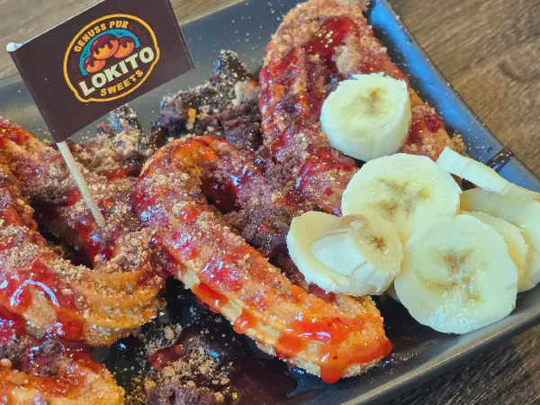 Churros plate with sauce, topping and fruit